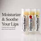 Three lip balm tubes from The Crystal Garden are displayed on a light gray background with promotional text on the left. The tubes are labeled Cocoa Butter, Hibiscus, and Sweet Mint botanical lip balm.
