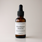A 1 oz amber glass dropper bottle of The Crystal Garden Woodsman Beard Oil with a black cap and white label, set against a plain light beige background.