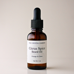 An amber glass dropper bottle of The Crystal Garden Citrus Spice Beard Oil with a black dropper cap and a white label, set against a solid light beige background.