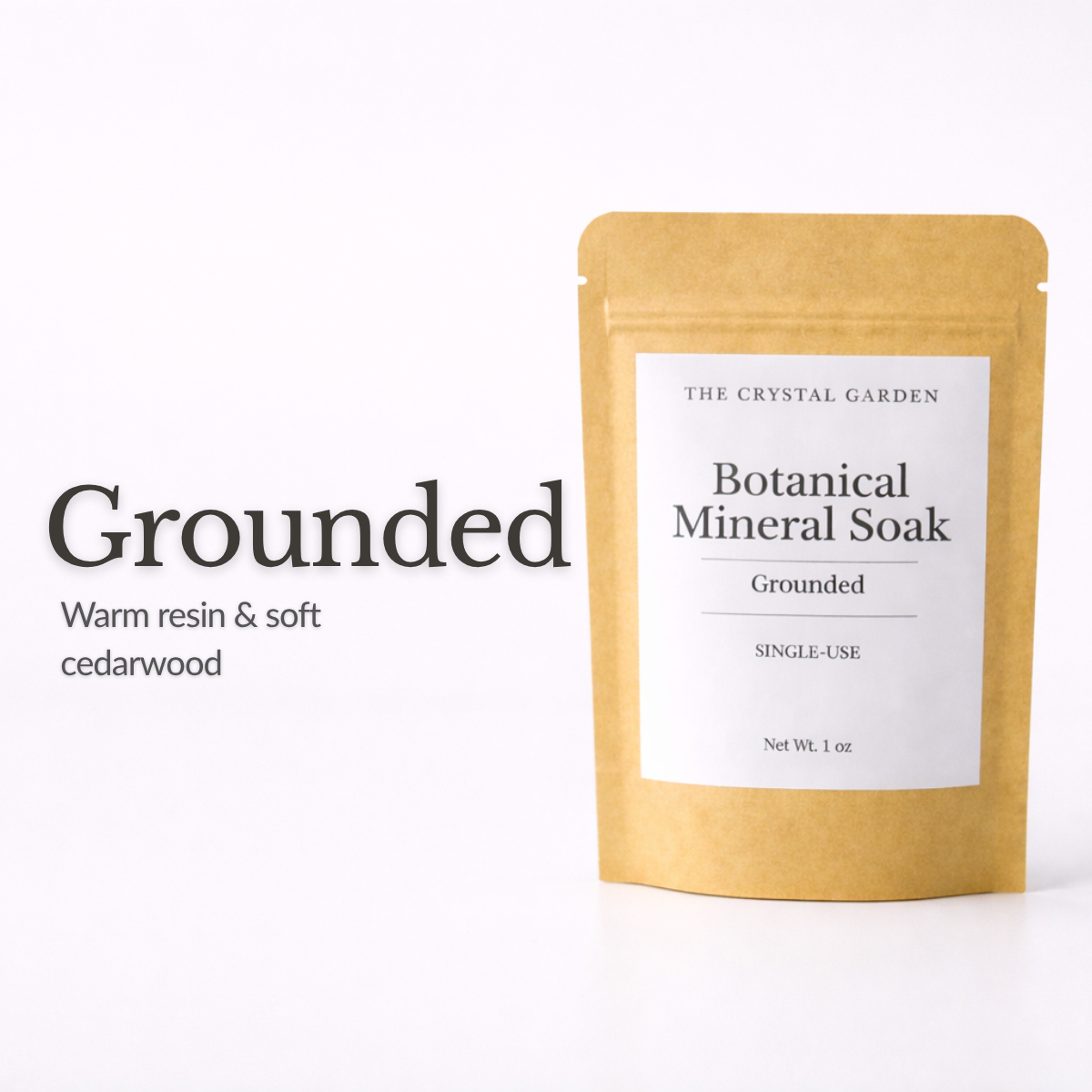A single-use kraft paper pouch of The Crystal Garden Grounded Botanical Mineral Soak, shown next to text describing the scent as warm resin and soft cedarwood on a white background.