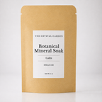 A single-use stand-up pouch of The Crystal Garden Botanical Mineral Soak in the 'Calm' scent, made of natural kraft paper with a white label.