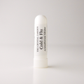 A white plastic cold and flu aromatherapy inhaler tube by The Crystal Garden, standing upright on a light gray background.