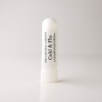 A white plastic cold and flu aromatherapy inhaler tube by The Crystal Garden, standing upright on a light gray background.