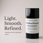 A black cylindrical deodorant stick with a white label reading 'THE CRYSTAL GARDEN Woodland Bouquet Natural Deodorant' stands on a light neutral background beside large text that says 'Light. Smooth.