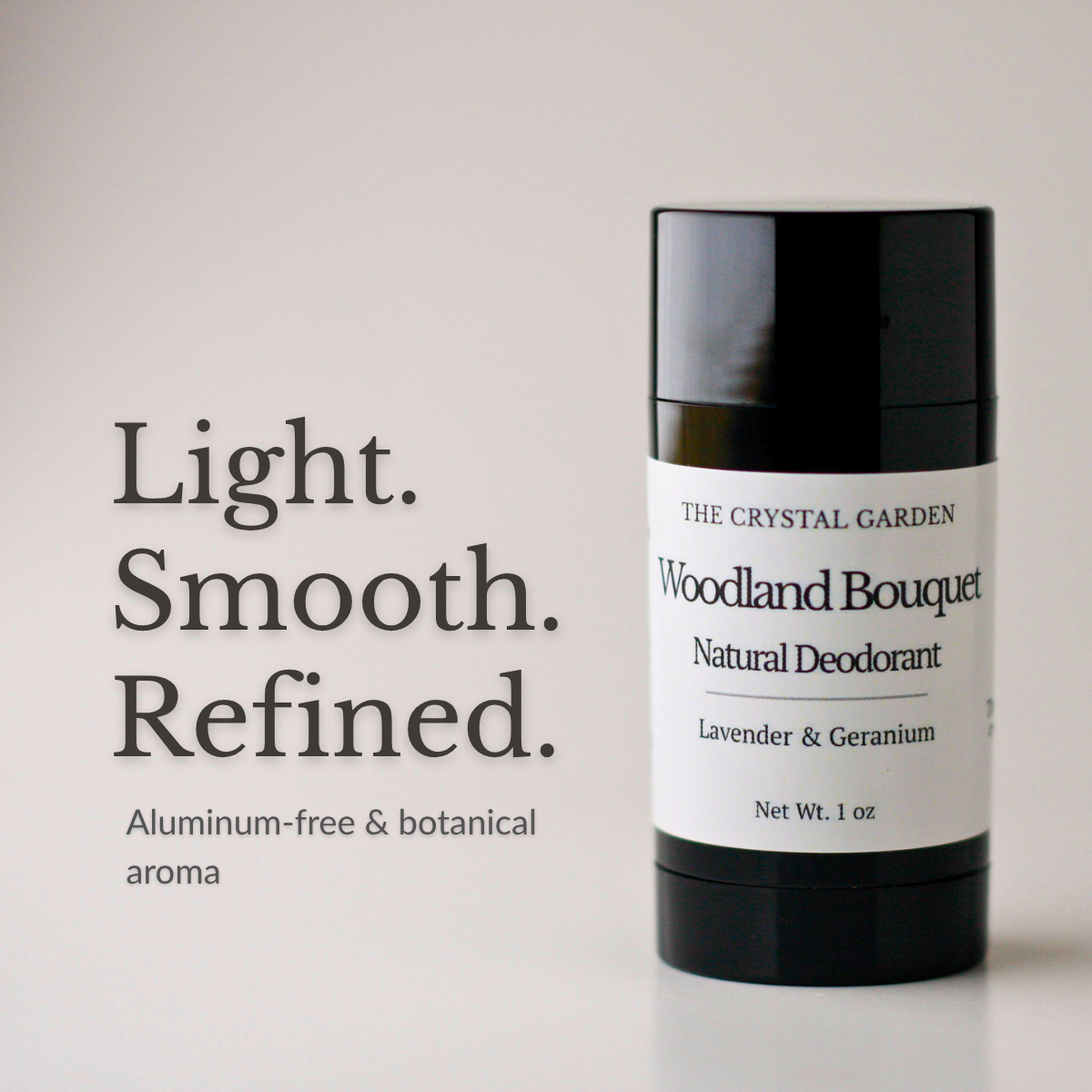 A black cylindrical deodorant stick with a white label reading 'THE CRYSTAL GARDEN Woodland Bouquet Natural Deodorant' stands on a light neutral background beside large text that says 'Light. Smooth.