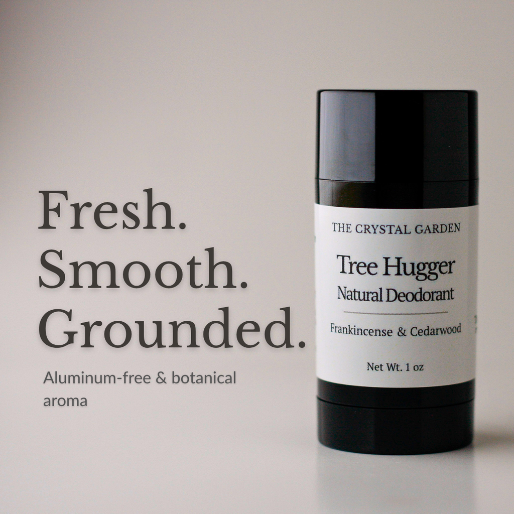 A black cylindrical deodorant stick with a white label reading 'THE CRYSTAL GARDEN Tree Hugger Natural Deodorant' stands on a light neutral background beside large text that says 'Fresh. Smooth.