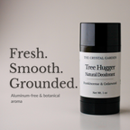 A black cylindrical deodorant stick with a white label reading 'THE CRYSTAL GARDEN Tree Hugger Natural Deodorant' stands on a light neutral background beside large text that says 'Fresh. Smooth.