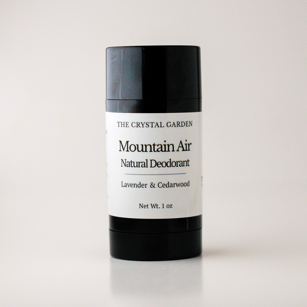 A black cylindrical deodorant stick container with a white label reading 'THE CRYSTAL GARDEN Mountain Air Natural Deodorant Lavender & Cedarwood' on a clean white background.