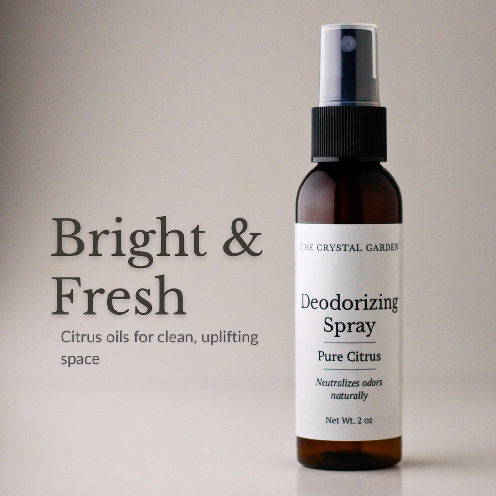 A 2 oz amber glass spray bottle of The Crystal Garden Deodorizing Spray in Pure Citrus scent, shown next to text that reads 'Bright & Fresh' and 'Citrus oils for clean, uplifting space' on a warm beige background.