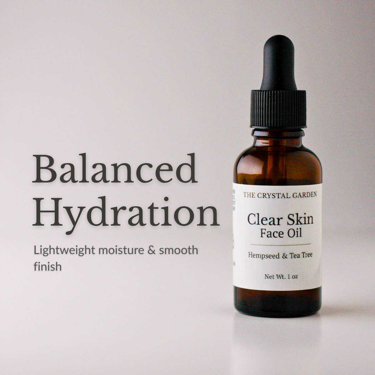 An amber glass dropper bottle of The Crystal Garden Clear Skin Face Oil with a black dropper cap and white label, shown next to text reading 'Balanced Hydration' on a light gray background.