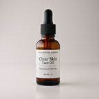 An amber glass dropper bottle of face oil with a black dropper cap and a white label reading 'THE CRYSTAL GARDEN Clear Skin Face Oil Hempseed & Tea Tree'.