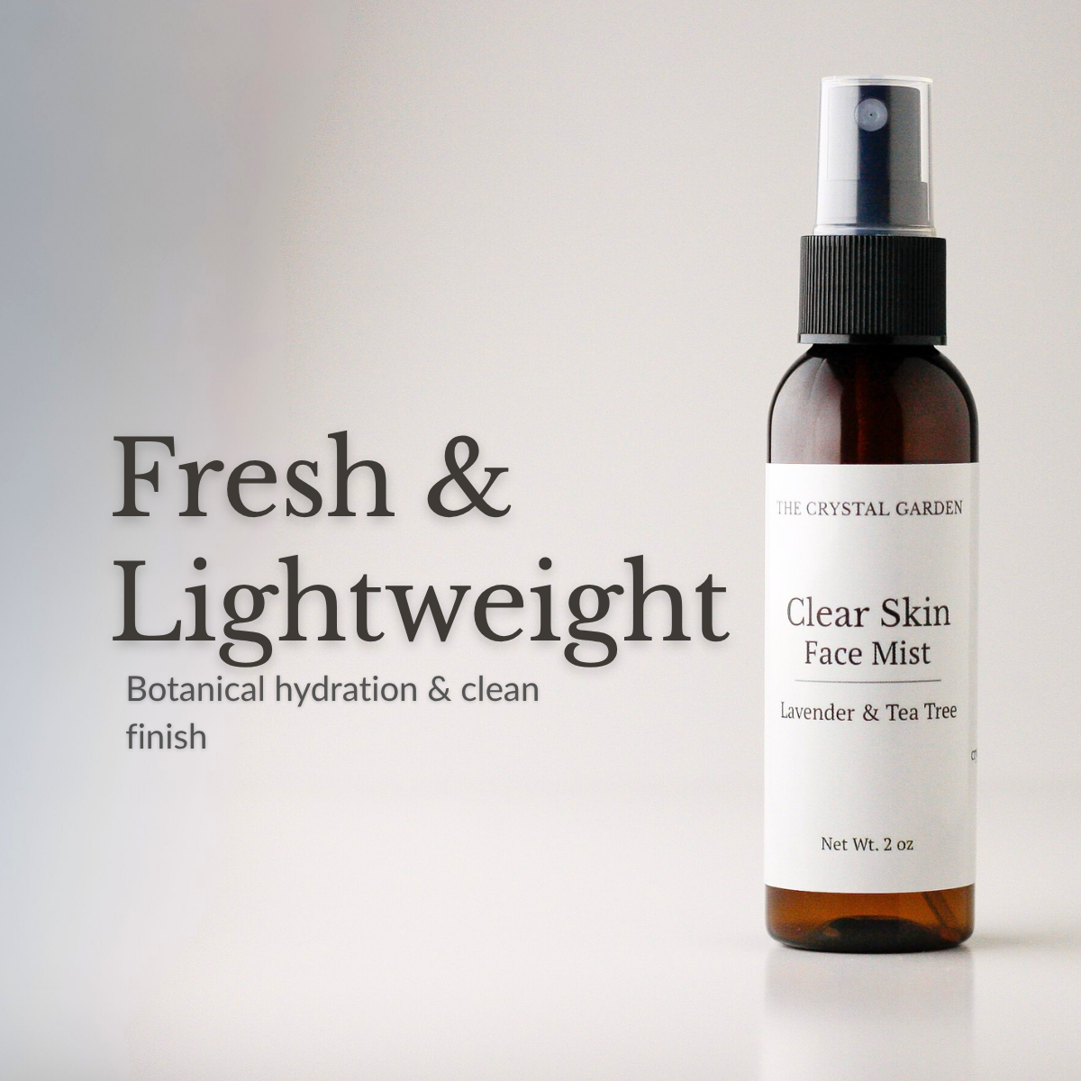 An amber glass spray bottle of face mist with a white label reading 'Clear Skin Face Mist' and 'The Crystal Garden,' shown on a light gray background with the text 'Fresh & Lightweight' and 'Botanical hydration & clean finish.'.