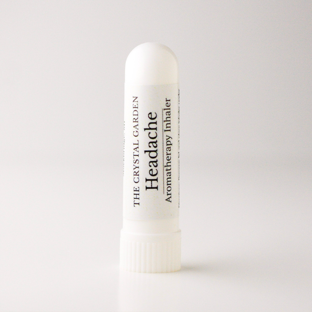 A white cylindrical tube of 'Headache' aromatherapy inhaler by The Crystal Garden, standing upright on a clean white background.