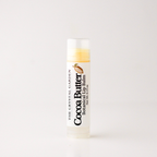 A single tube of The Crystal Garden Cocoa Butter Botanical Lip Balm on a clean white background.