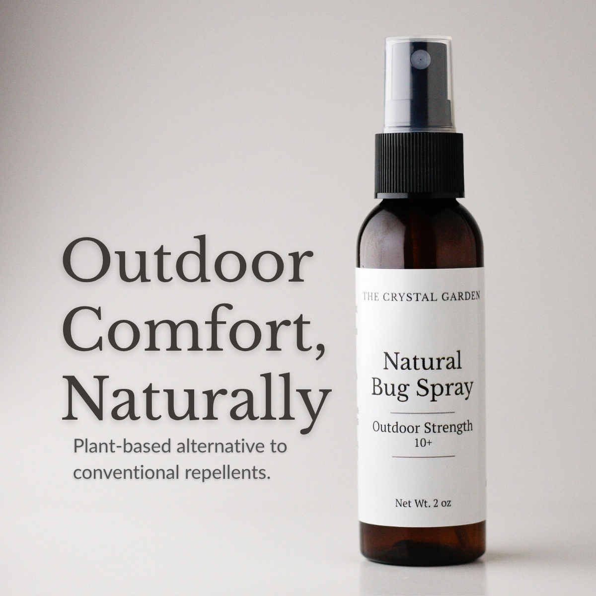 A 2 oz amber spray bottle of The Crystal Garden Natural Bug Spray with a white label and black spray nozzle, shown next to the text 'Outdoor Comfort, Naturally' on a light gray background.