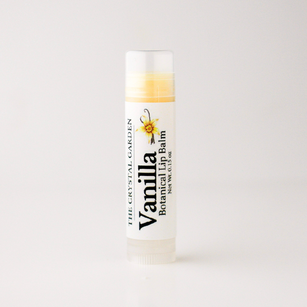 A single tube of lip balm standing upright on a clean white background. The label reads 'Vanilla Botanical Lip Balm' and shows 'The Crystal Garden' with a vanilla flower illustration.