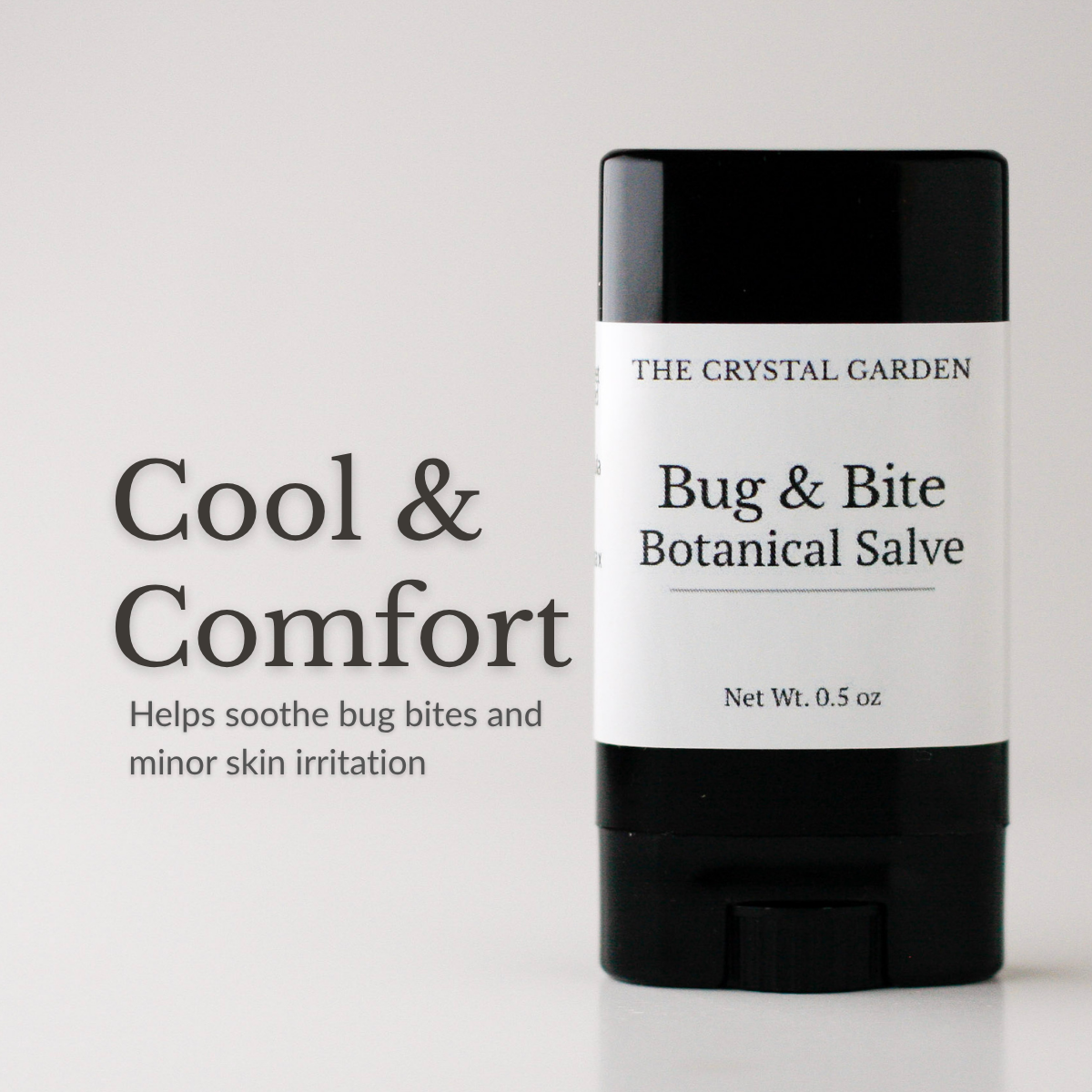 A black and white stick of The Crystal Garden Bug & Bite Botanical Salve stands on a white surface against a light gray background, with text on the left reading 'Cool & Comfort'.
