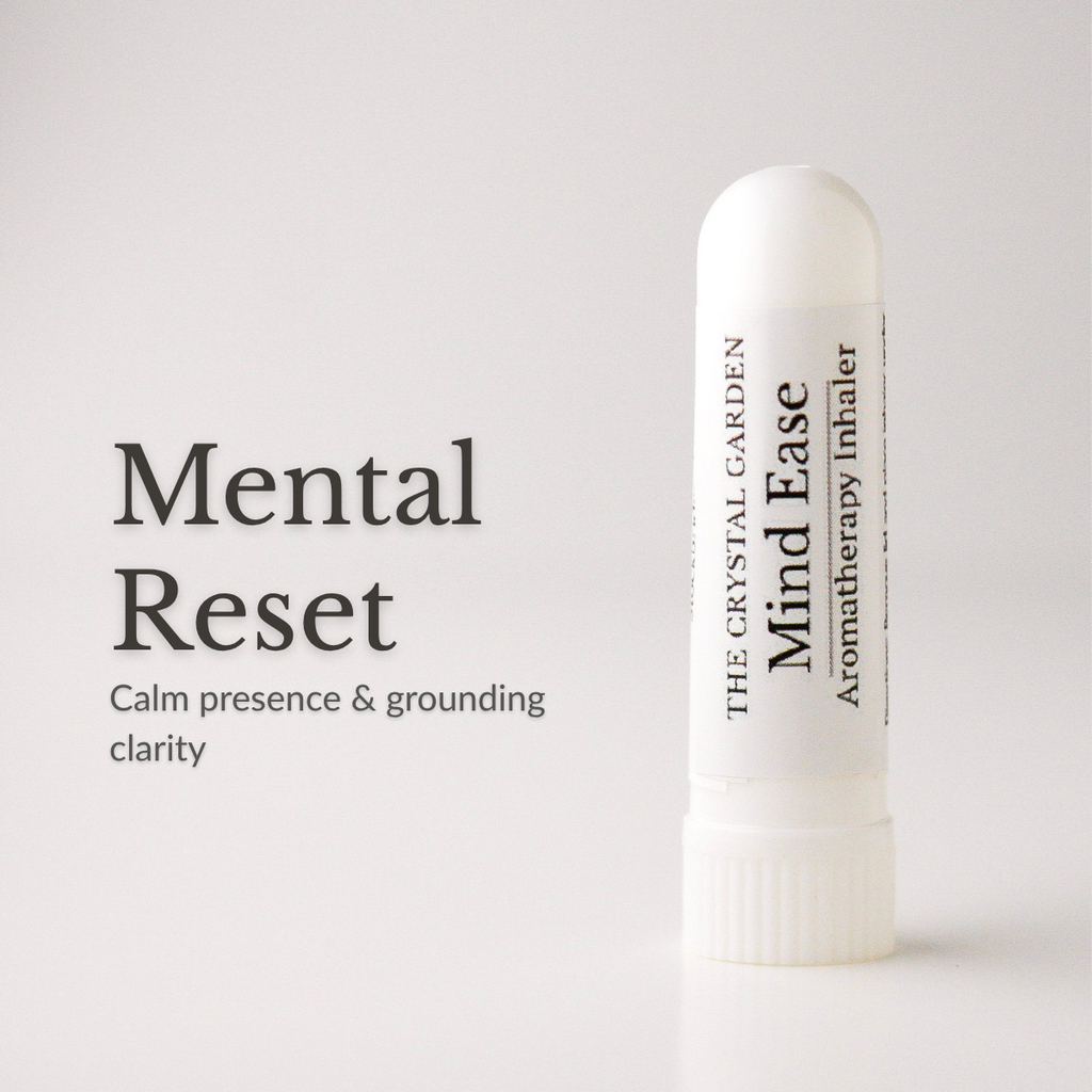 A white cylindrical aromatherapy inhaler tube labeled 'The Crystal Garden Mind Ease' stands on a light gray background beside large text reading 'Mental Reset' and smaller descriptive copy.
