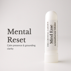 A white cylindrical aromatherapy inhaler tube labeled 'The Crystal Garden Mind Ease' stands on a light gray background beside large text reading 'Mental Reset' and smaller descriptive copy.