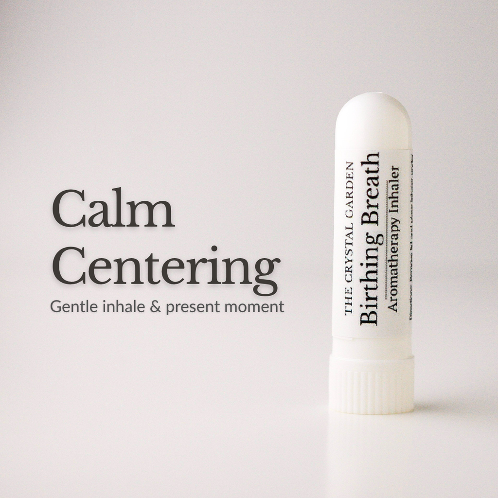 A white cylindrical aromatherapy inhaler tube stands on a light gray background next to the text 'Calm Centering' and 'Gentle inhale & present moment.' The tube is labeled 'The Crystal Garden Birthing Breath Aromatherapy inhaler.