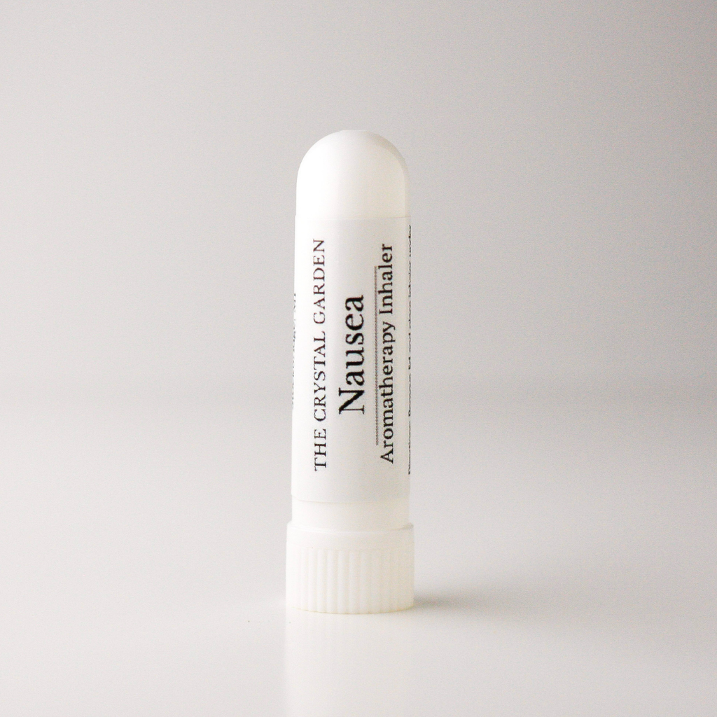 A white cylindrical nasal spray bottle labeled 'Nausea' by The Crystal Garden Aromatherapy Inhaler, standing upright on a light gray background.
