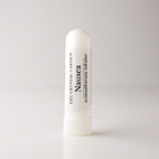 A white cylindrical nasal spray bottle labeled 'Nausea' by The Crystal Garden Aromatherapy Inhaler, standing upright on a light gray background.