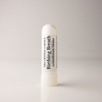 A white cylindrical aromatherapy inhaler tube with a ribbed screw cap, standing upright on a light gray background. The label reads 'THE CRYSTAL GARDEN Birthing Breath Aromatherapy inhaler'.