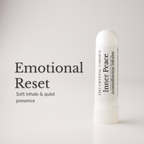 A white cylindrical aromatherapy inhaler bottle stands on a light gray background next to black text that reads 'Emotional Reset' and 'Soft inhale & quiet presence.' The bottle label shows 'The Crystal Garden' and 'Inner Peace.