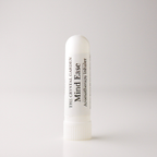 A white cylindrical aromatherapy inhaler tube standing upright on a light gray background. The label reads 'THE CRYSTAL GARDEN Mind Ease Aromatherapy Inhaler' in black text.