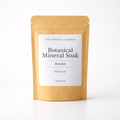 A single-use stand-up pouch of The Crystal Garden Botanical Mineral Soak in the Restore scent, made of natural kraft paper with a white label, shot against a clean white background.
