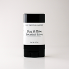 A single stick of 'Bug & Bite Botanical Salve' by 'The Crystal Garden' in a black and white container, centered on a light gray background.