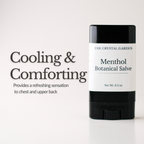 A black and white stick of The Crystal Garden Menthol Botanical Salve stands on a white surface against a white background, with text on the left reading 'Cooling & Comforting'.