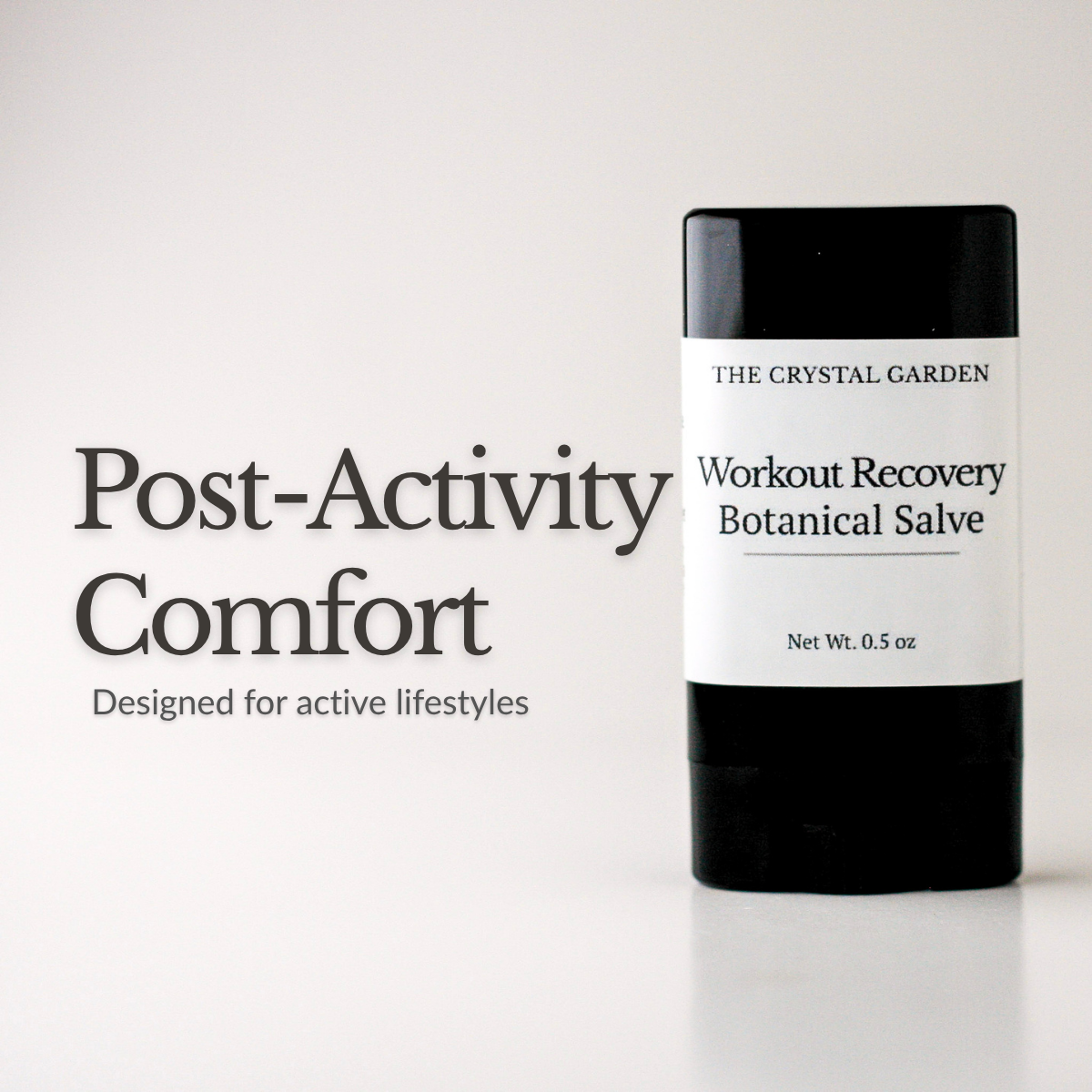 A black and white stick of The Crystal Garden Workout Recovery Botanical Salve stands on a white surface next to the text 'Post-Activity Comfort' on a clean white background.