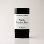 A single stick of salve from The Crystal Garden, specifically 'Calm Botanical Salve', in a black container with a white label, set against a plain light background.